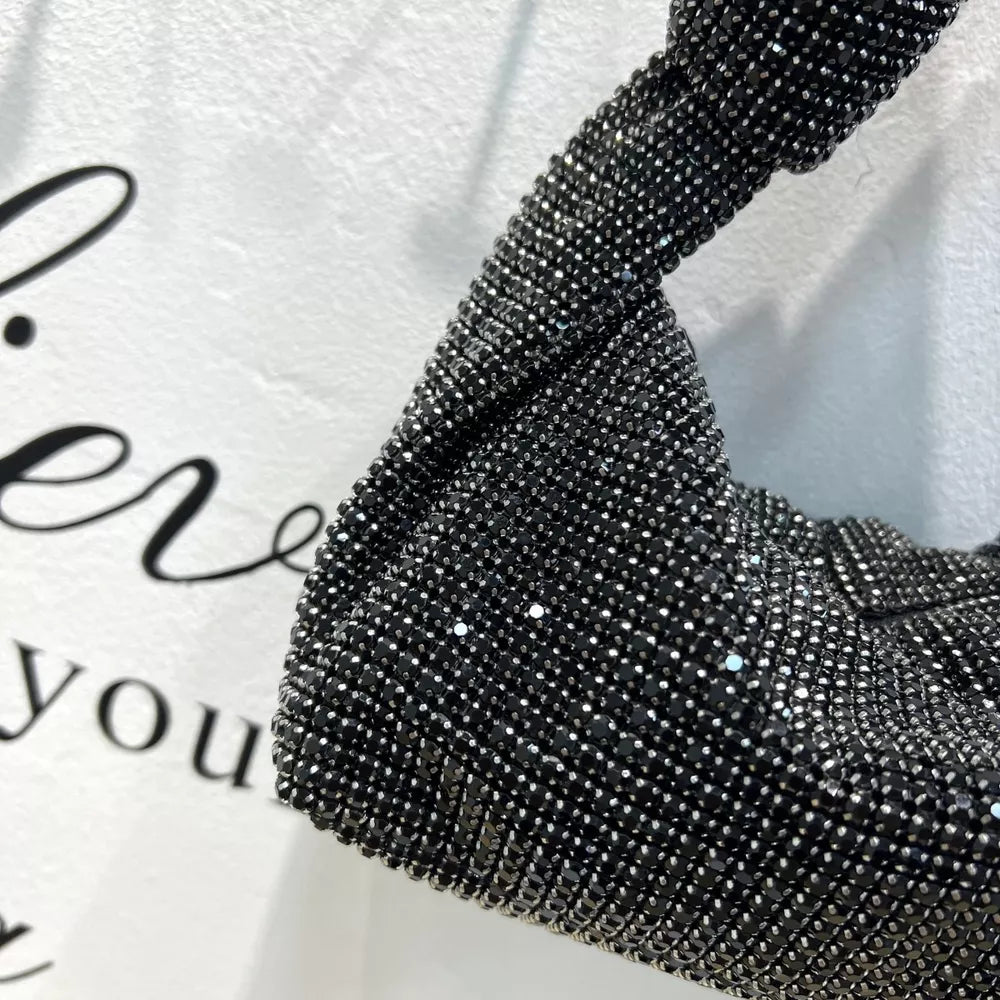 Black rhinestone crescent tote bag with twisted strap detail.