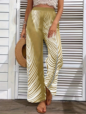 Khaki palazzo trousers with white palm print and a side slit, styled with a crochet top and sandals.