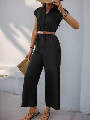 Black cap-sleeve button-down wide-leg jumpsuit with a brown belt and straw clutch.