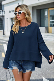 Navy acrylic knit sweater with flared sleeves and slit hem detail.