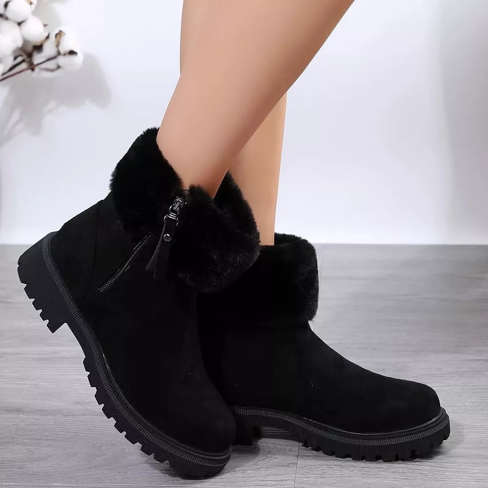 Black suede ankle boots with side zipper and faux fur trim on a chunky sole.