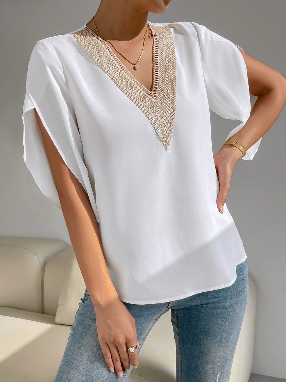 White blouse with lace trim V-neck and cape sleeves