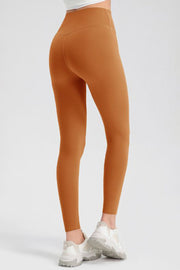 Caramel high-waist performance leggings with sculpting seams and a full-length cut.