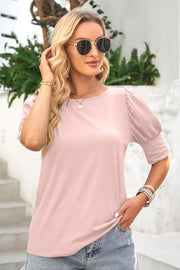 Blush pink blouse with puffed sleeves and cuff detail.