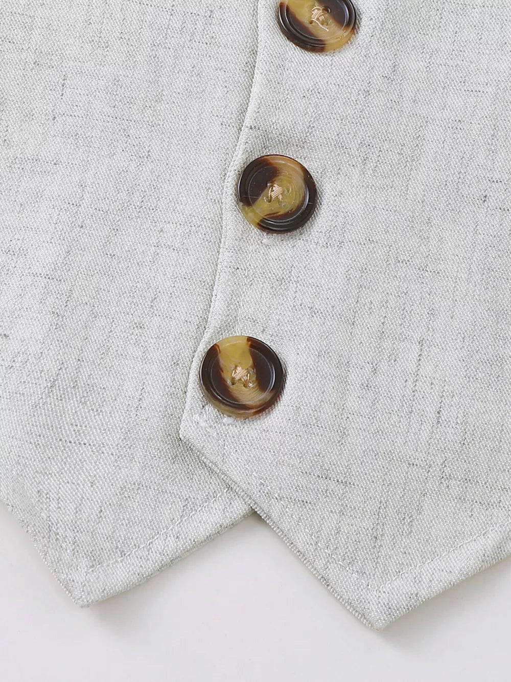 Baby vest with tortoise shell buttons and subtle texture