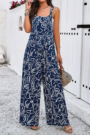 Dark blue wide leg jumpsuit with abstract white print, square neck and button straps.