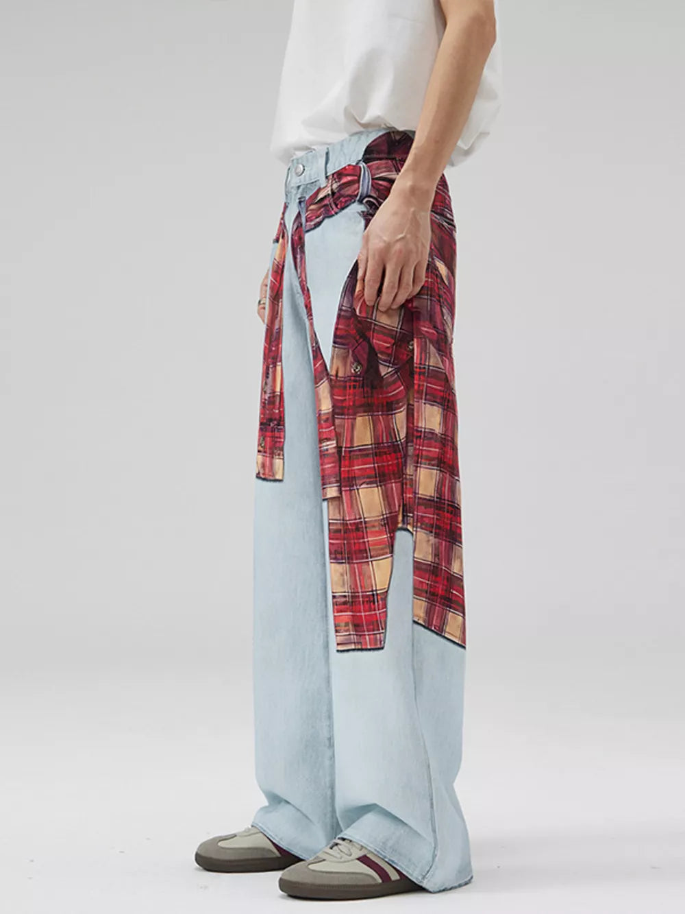 Men's light wash denim jeans with red plaid patchwork and wide legs.