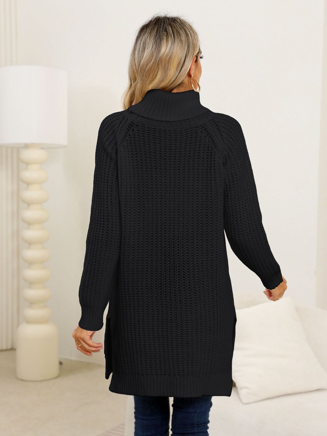 Black ribbed knit turtleneck tunic with side slits and long sleeves.