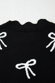 Black knit vest with white bow print and scalloped neckline