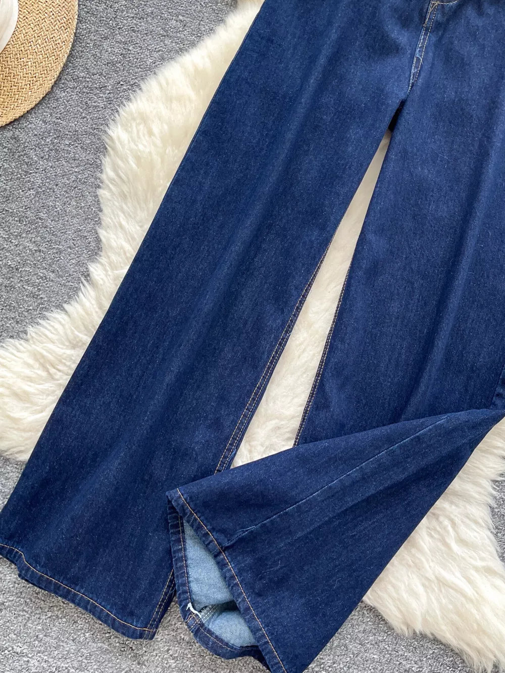 Dark wash maternity jeans with wide legs and a high rise, shown up close.