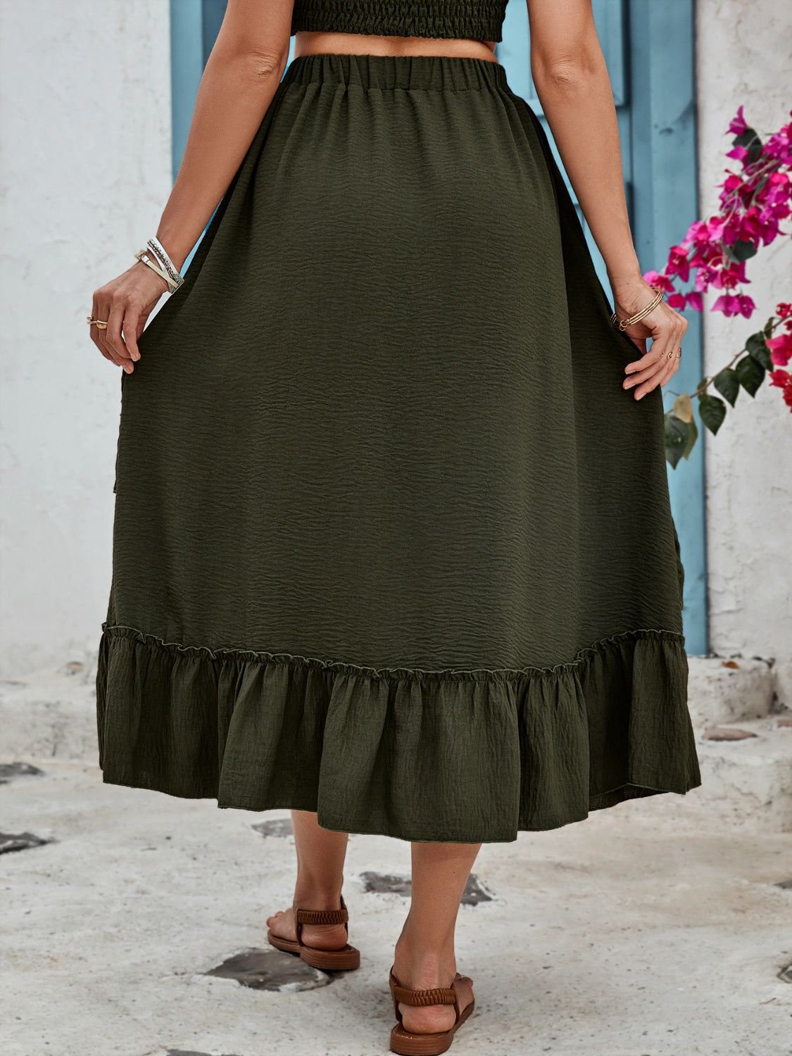 Tiered midi skirt in dark green with textured fabric and ruffled hem.