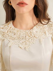 Apricot lace trimmed short-sleeve blouse with floral neckline detail.