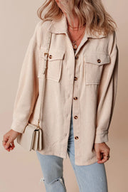 Beige corduroy oversized utility jacket with button-flap chest pockets and a relaxed fit.