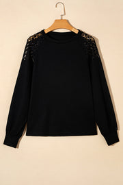 Black waffle knit raglan top with lace yoke detail and long sleeves.