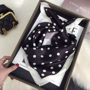 Black silk scarf with white polka dots and a cream border.