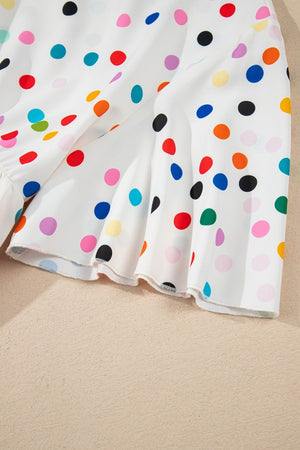 White polka dot blouse with tiered flutter sleeves and ruffled hem detail.