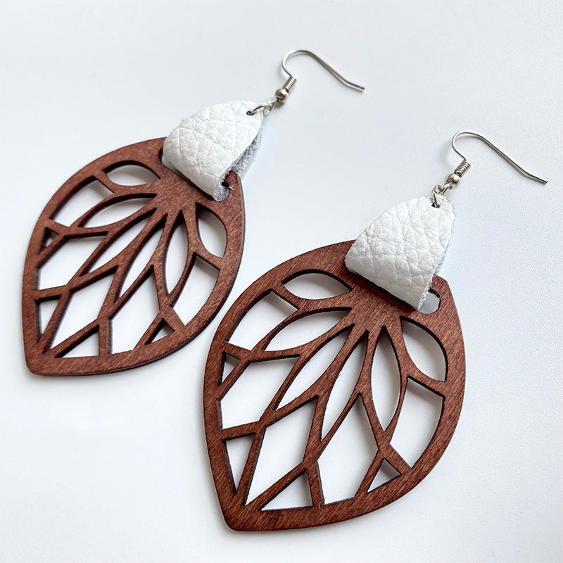 Leaf cutout wood dangle earrings with white leather accent.