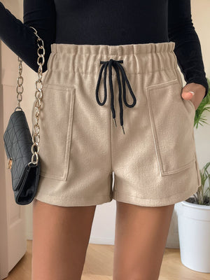 Tan paperbag waist utility shorts with drawstring and patch pockets.
