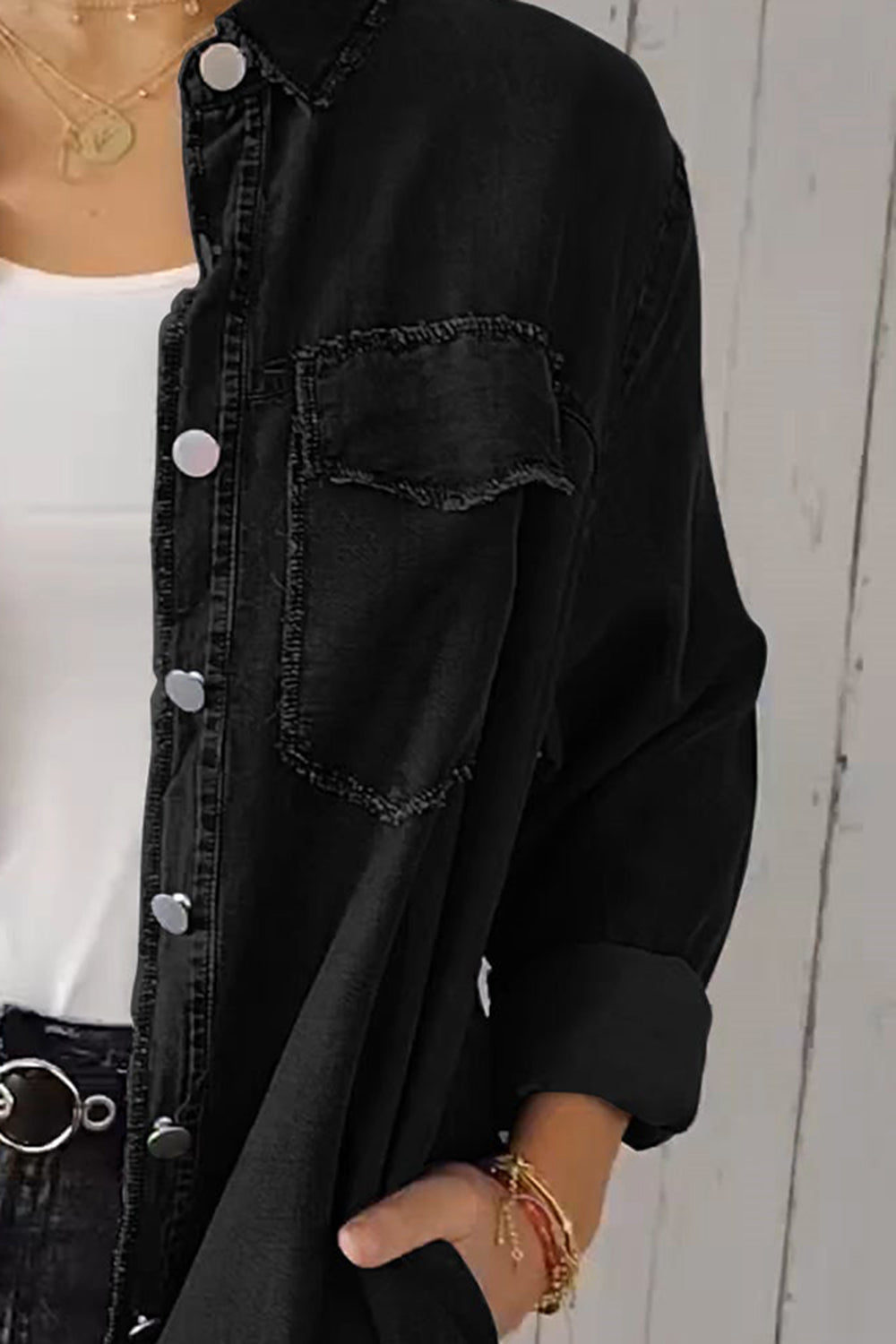 Black oversized denim shirt jacket with frayed pocket details and silver buttons.