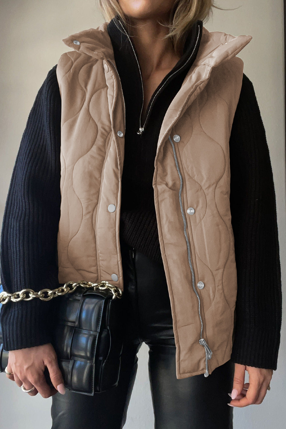 Quilted stand-collar gilet in beige with zip and snap front closure.