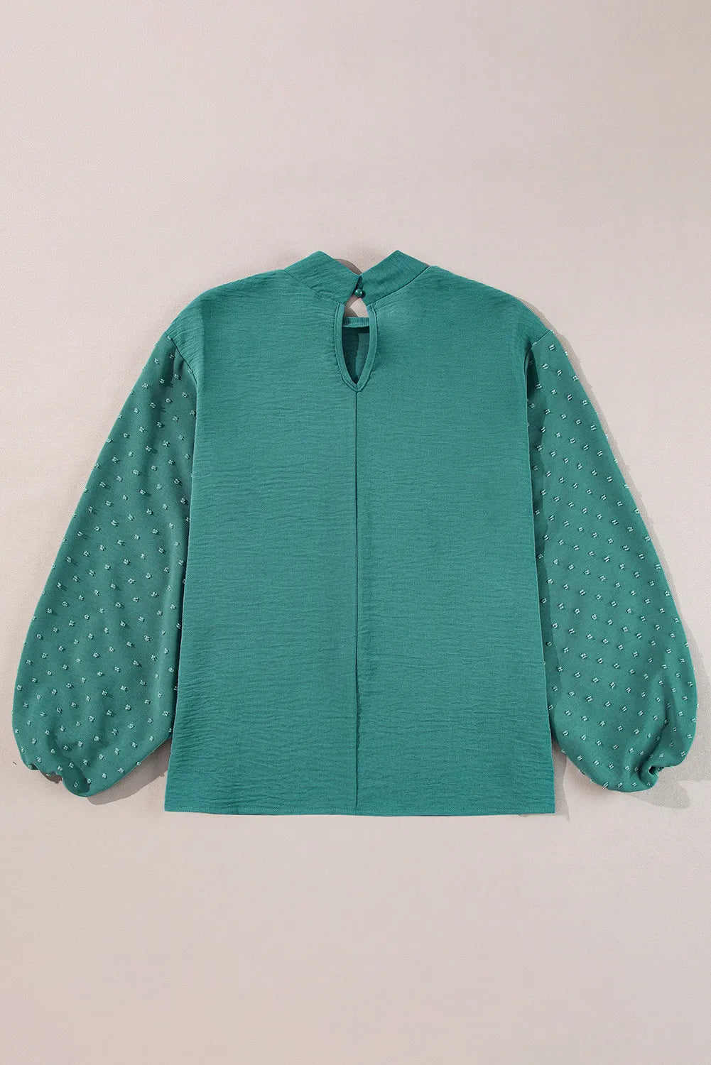 Teal blouson blouse with textured fabric and Swiss dot balloon sleeves.