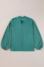 Teal blouson blouse with textured fabric and Swiss dot balloon sleeves.