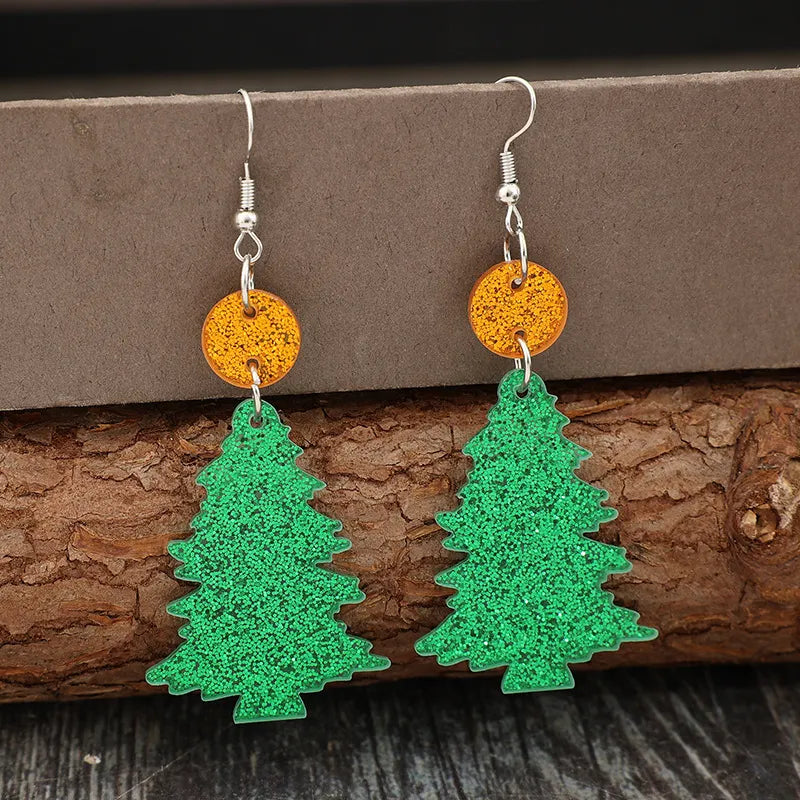 Glittering green acrylic Christmas tree drop earrings with orange circle accents.