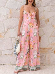 Pink architectural print tie-front wide-leg jumpsuit with bow detail and spaghetti straps.