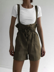 Moss high-waisted drawstring suspender shorts with pockets and a tie waist.