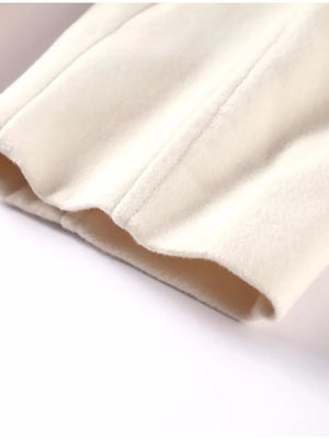 Beige trench coat detail showing fabric texture and stitching.