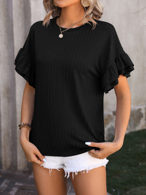 Black textured blouse with flutter sleeves and crew neck, styled with white shorts.