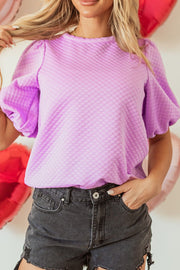 Textured quilted puff sleeve blouse in pink purple with a round neckline.