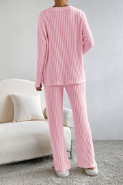 Wide-leg ribbed knit lounge set in carnation pink, featuring a crewneck top and relaxed pants.