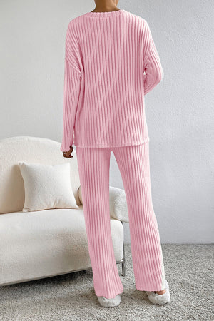 Wide-leg ribbed knit lounge set in carnation pink, featuring a crewneck top and relaxed pants.