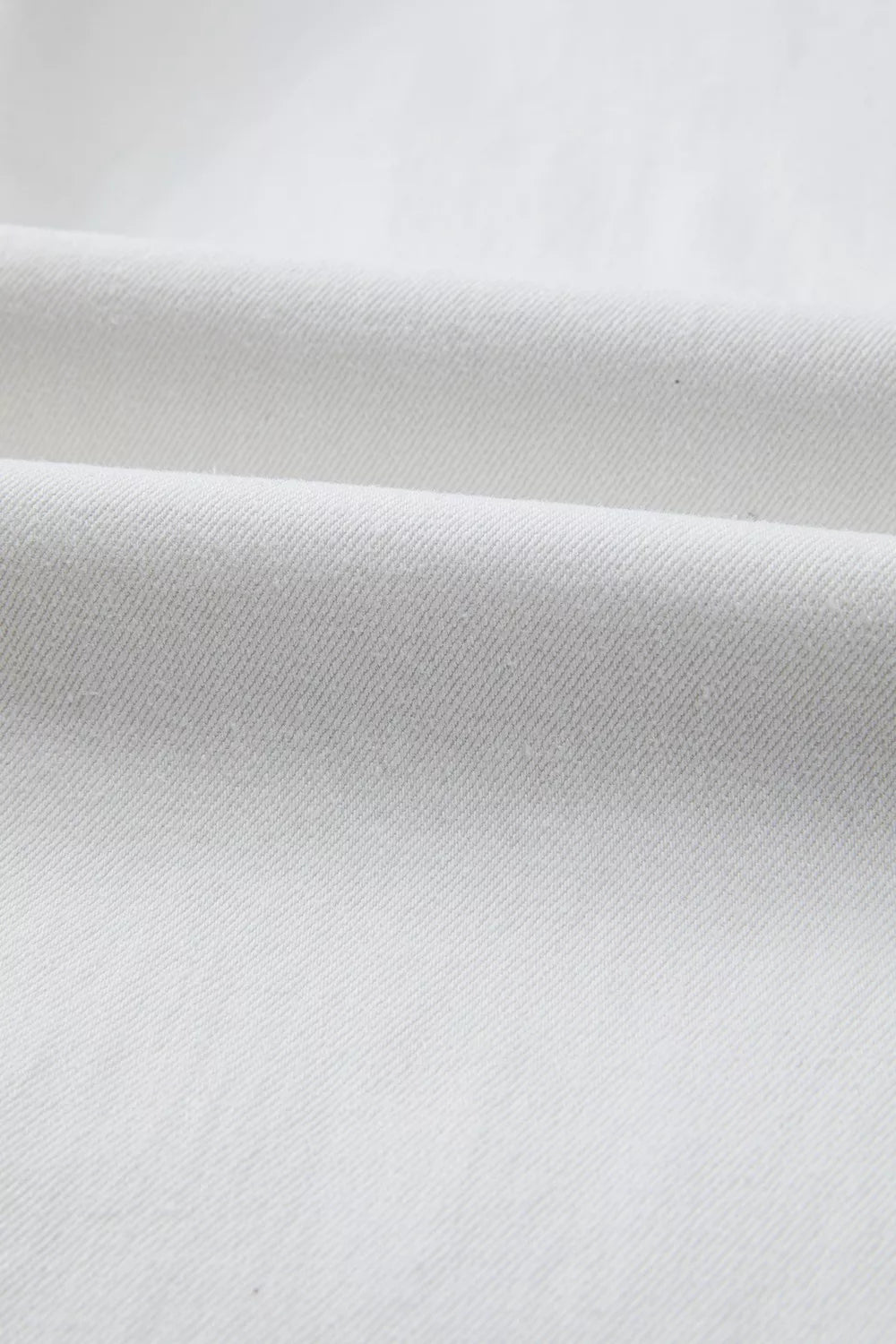 White cotton denim fabric detail of high-waisted straight leg jeans