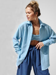 Light blue textured cotton overshirt with relaxed fit and button front, styled open over a bralette.