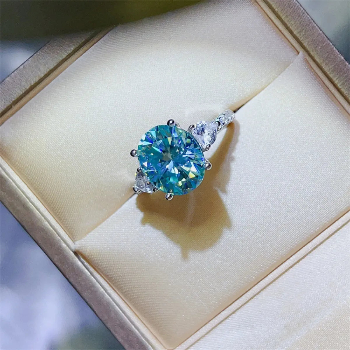 Turquoise moissanite trilogy ring in 925 sterling silver with a large round center stone.