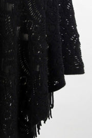 Black crochet poncho with open knit pattern and fringe detail