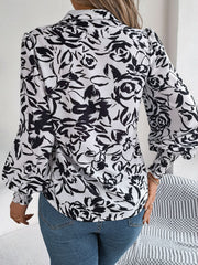 White floral print blouse with shirred cuffs and buttoned front detail.