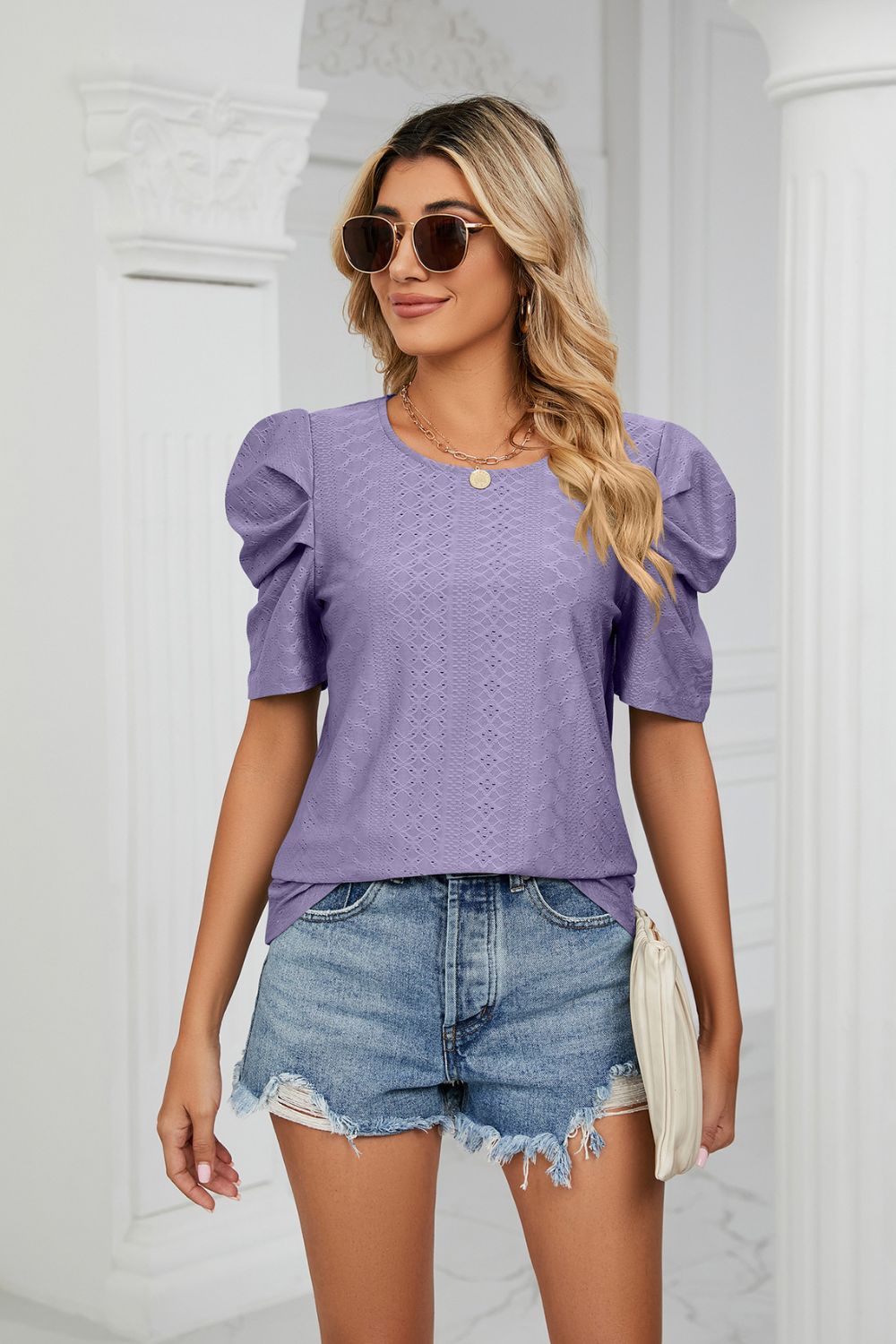 Perforated sleeve purple blouse with a textured pattern and round neckline.