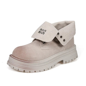Light gray suede platform boots with fold-over cuff and black branding detail.