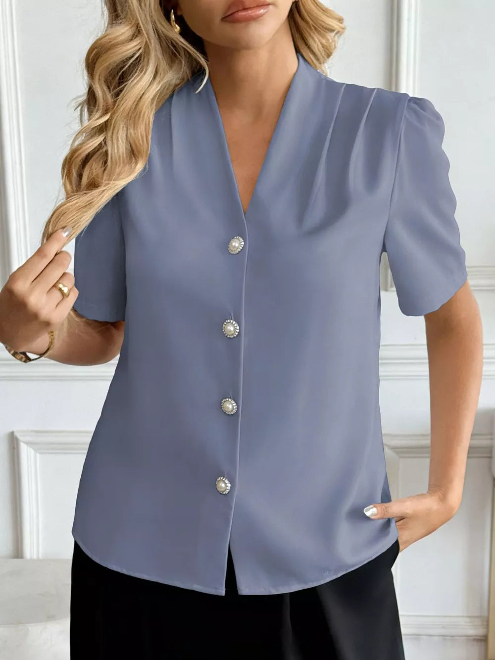Blue V-neck short sleeve shirt with pearl buttons and subtle shoulder pleats.