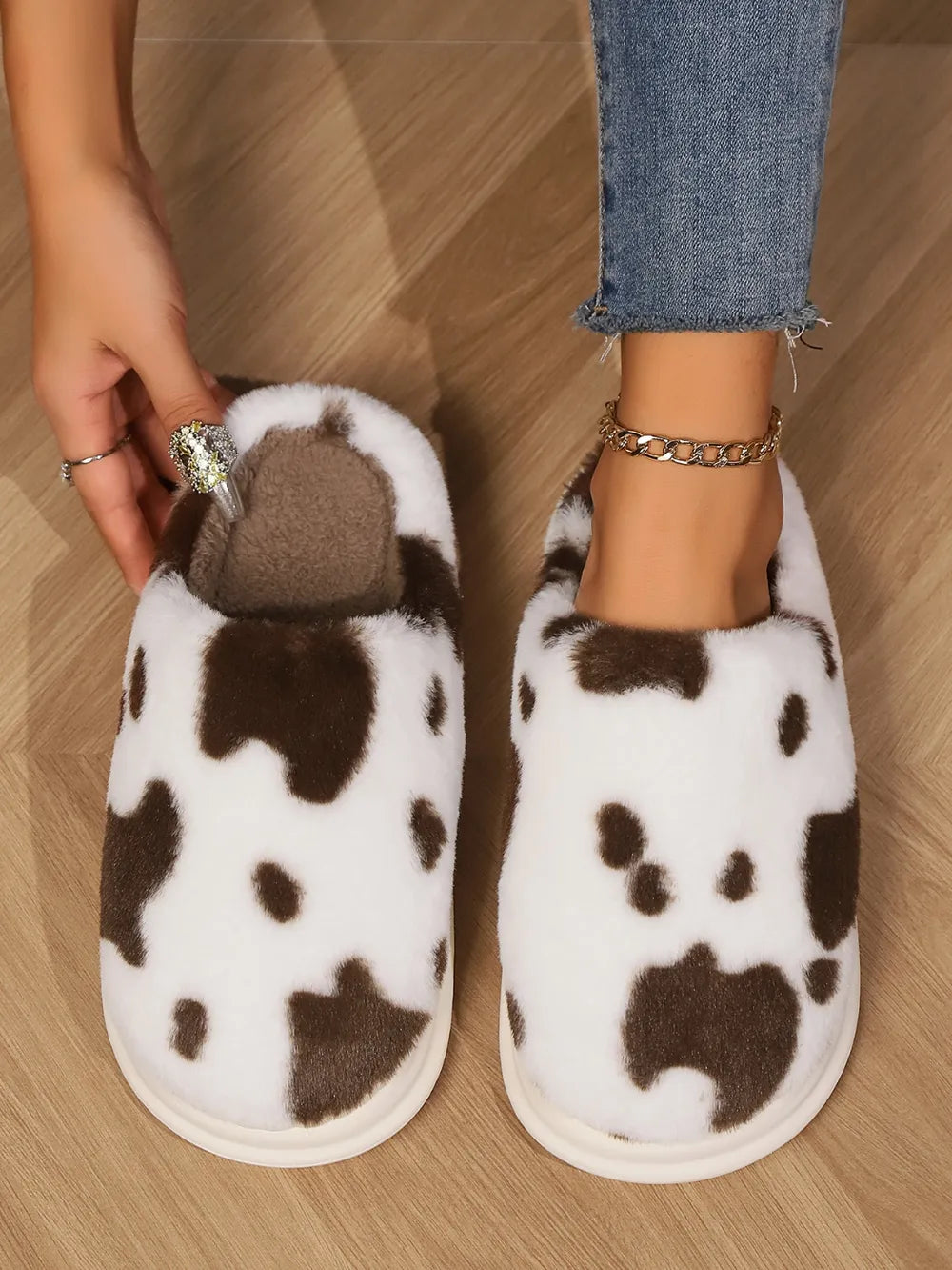Cow print faux fur house slides in white and brown, with plush lining.