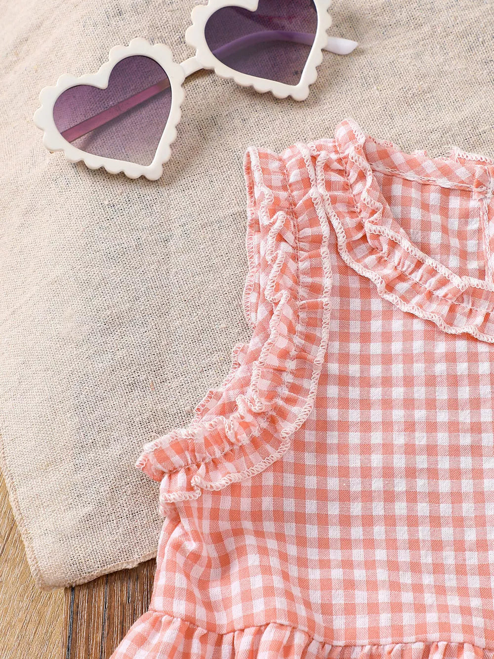 Pink gingham baby set with ruffled neckline and sleeves.