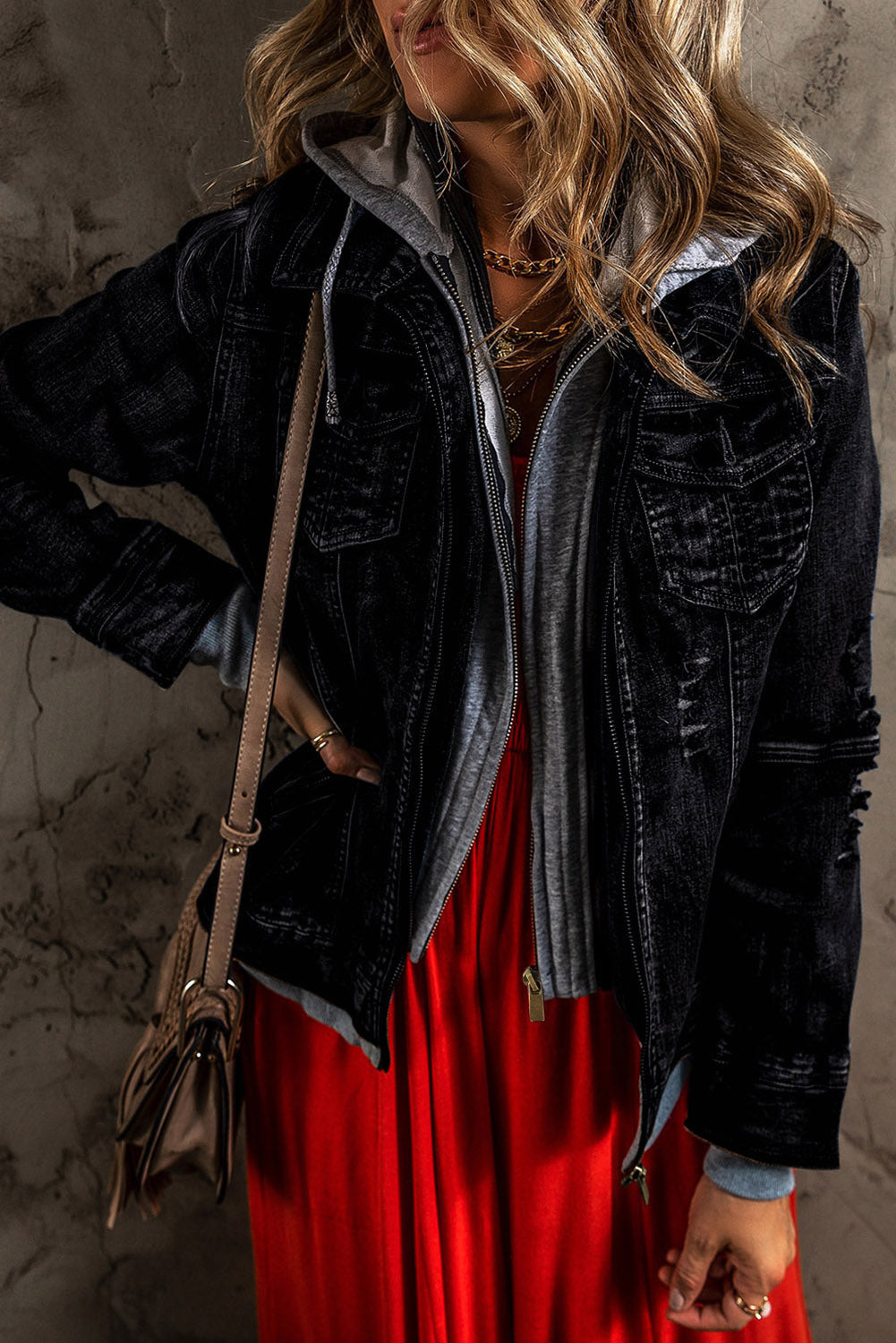 Black denim jacket with gray hooded layer, distressed details, buttoned front.