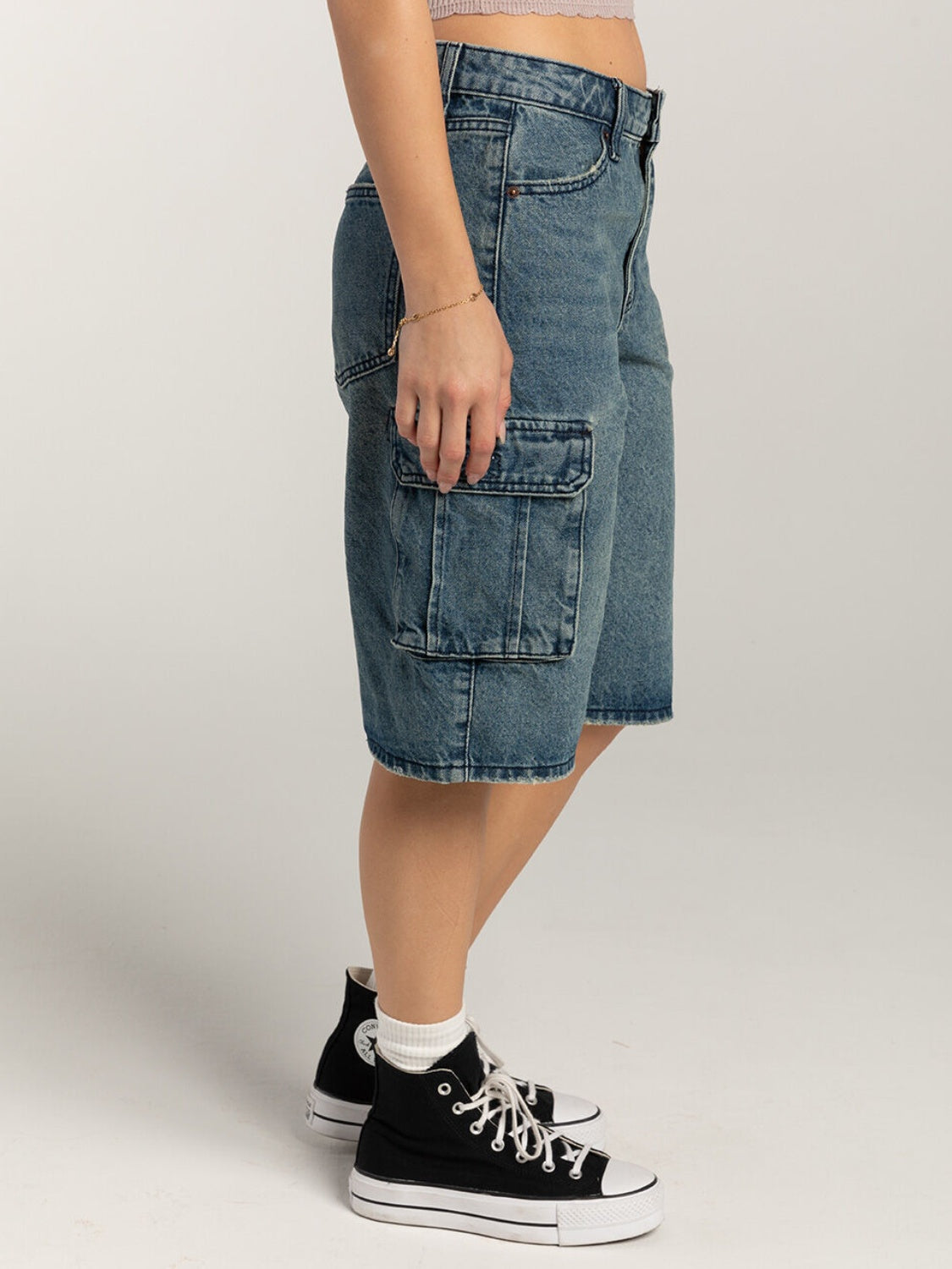 Light blue denim cargo bermuda shorts with buttoned flap pockets.