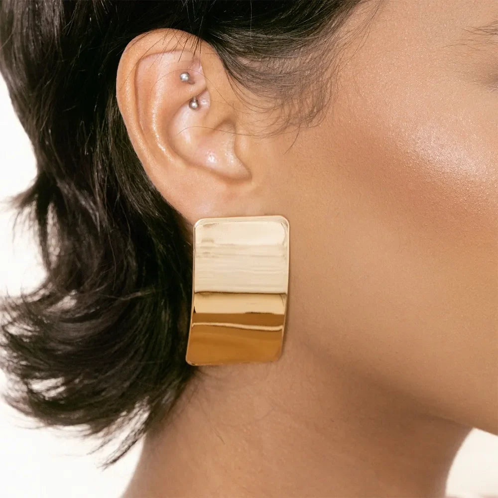Sculpted gold-tone statement earrings with a bold, casual style.