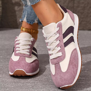 Two-tone suede lace-up sneakers in pink purple with white laces and purple stripes.