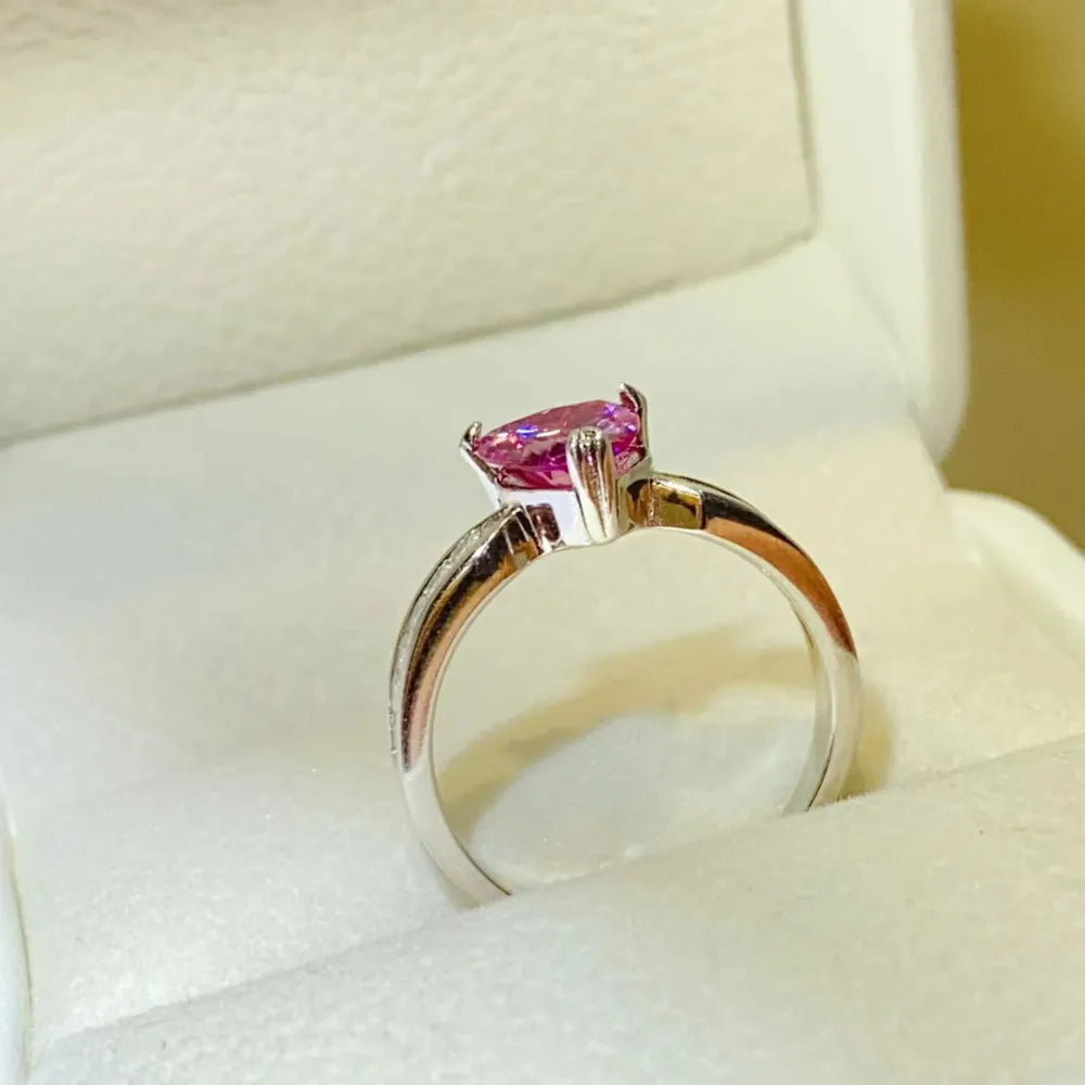Silver ring with a pink heart-cut gemstone and baguette accents.