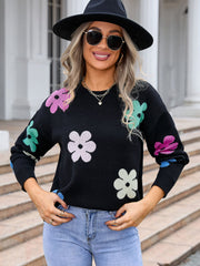 Black crewneck sweater with colorful floral print, long sleeves, acrylic knit.
